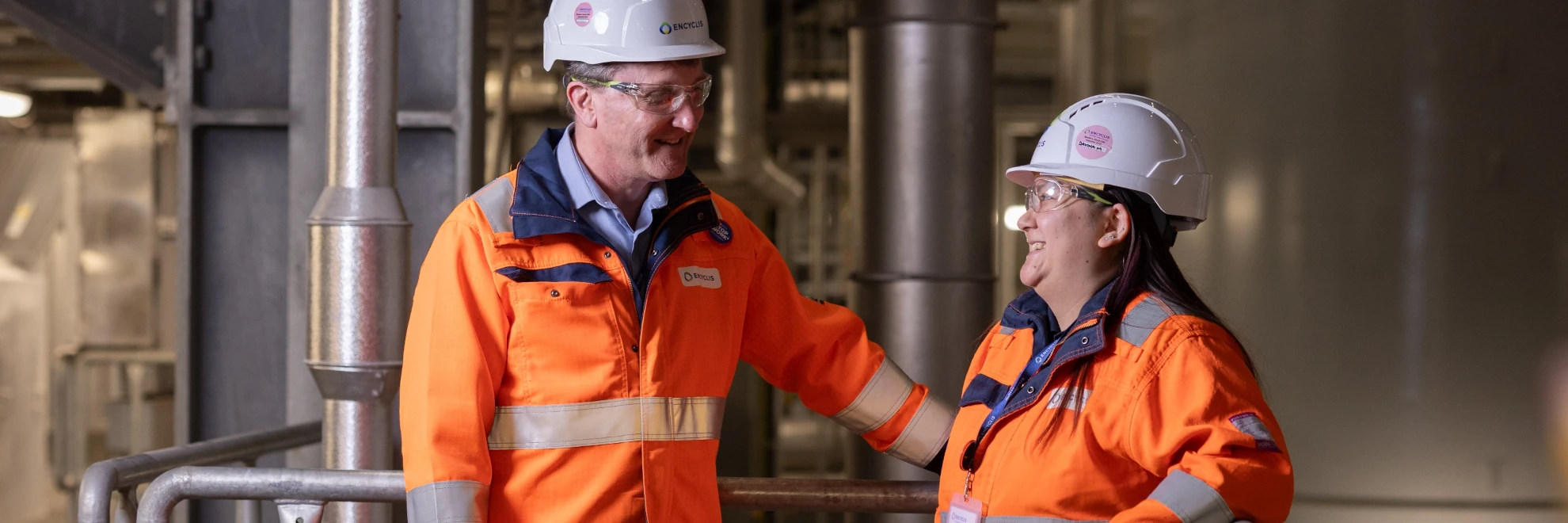 Picture of 2 people wearing high vis in a facility
