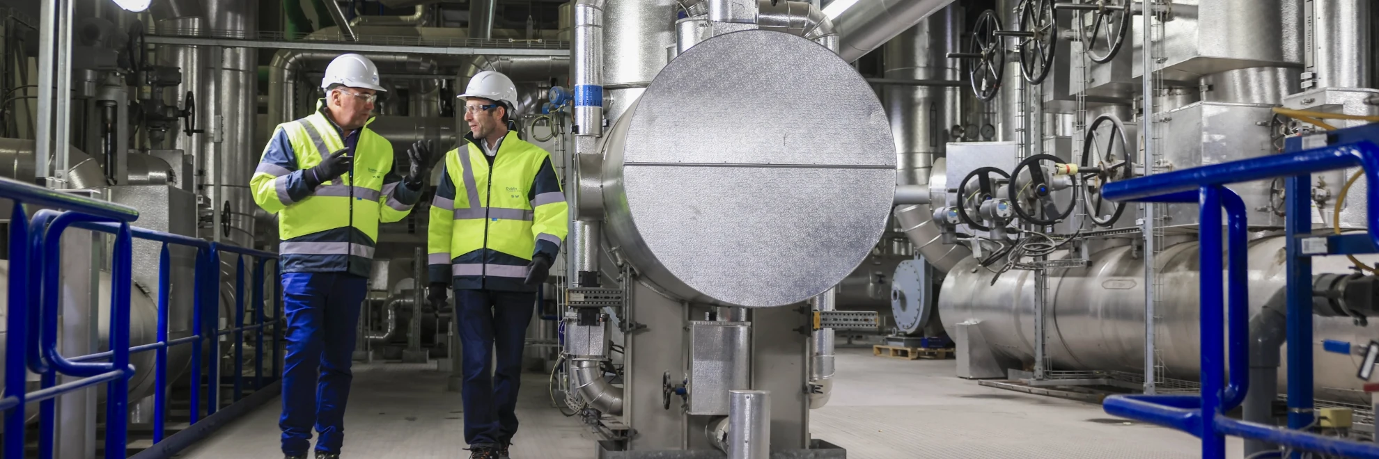 2 men in high-vis near an industrial boiler