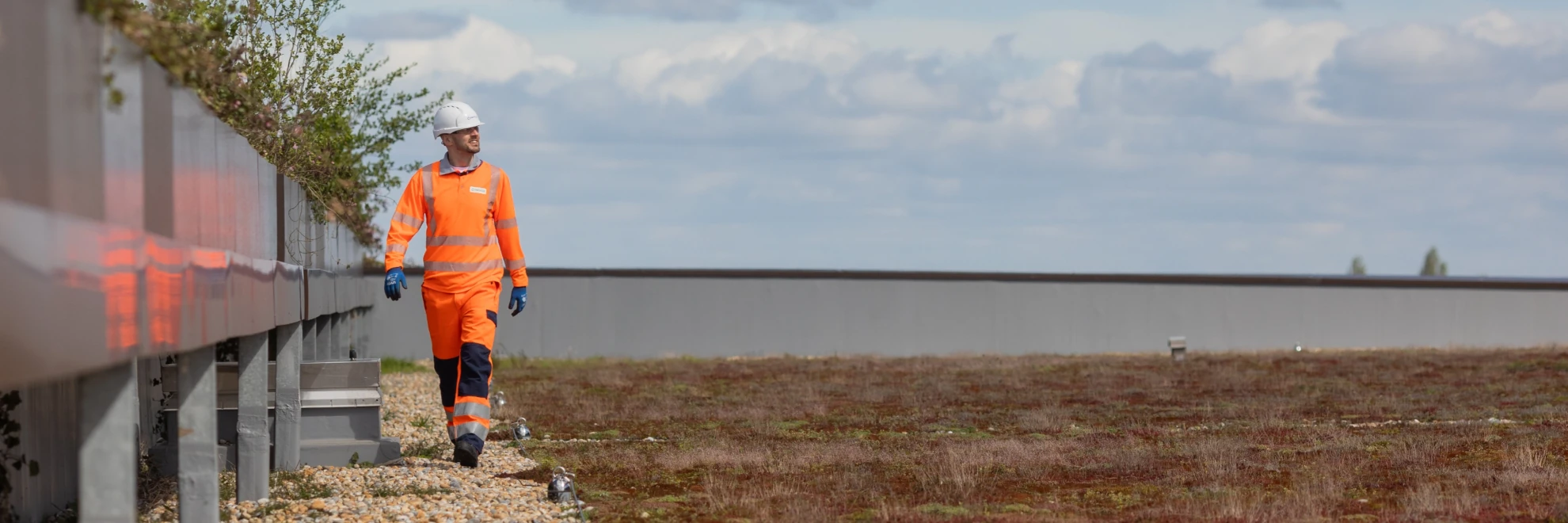 Man walking in high vis next to a body of water
